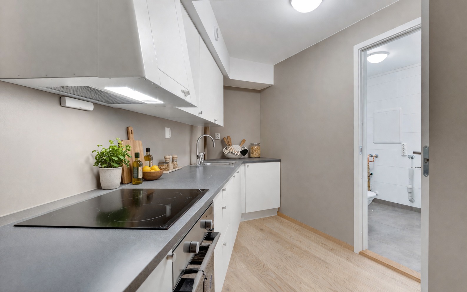 Kjøkkenet ligger i åpen forbindelse med stuen, noe som gjør det enkelt å kombinere matlaging og sosialt samvær. Tidløse materialvalg gir et rent og moderne uttrykk.